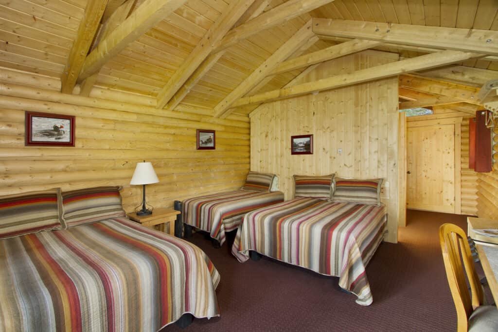 A warm and inviting cabin interior with rustic Alaska finishes and three beds