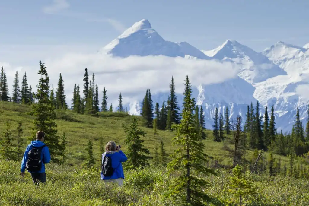 Two photographers in front of a snow-covered mountain