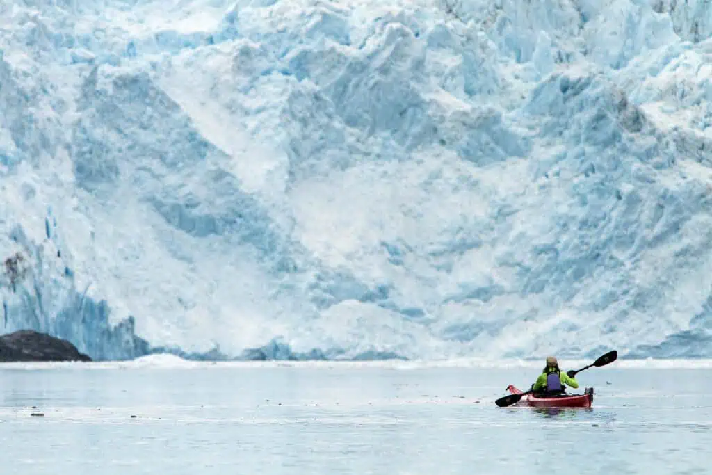 A single kayak in front of Aialik Glacier