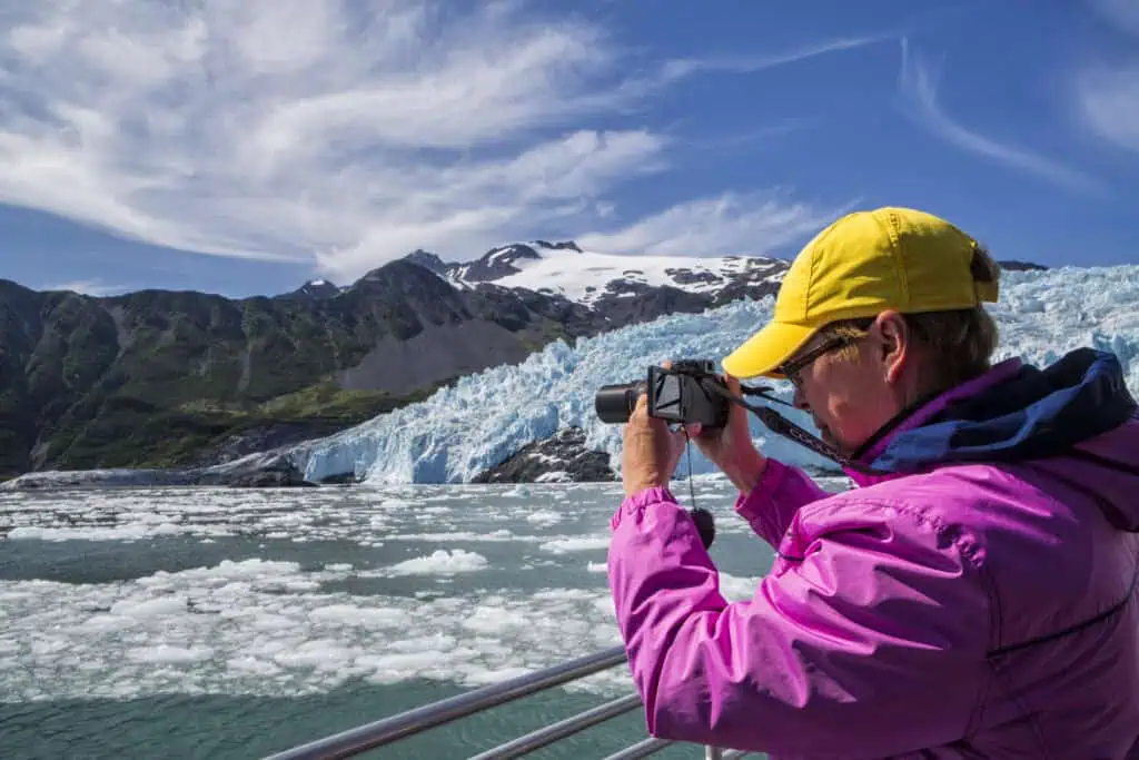 A traveler taking an image of the ice in Aialik Bay near Aialik Glacier