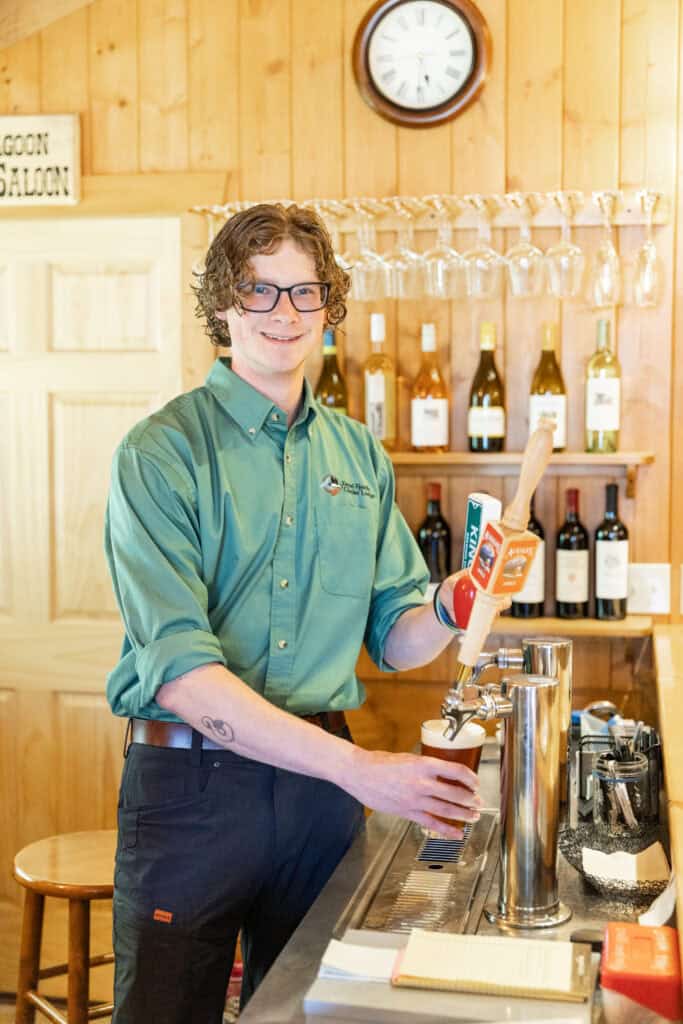 A staff member at Kenai Fjords Glacier Lodge pours a cold beer for a guest