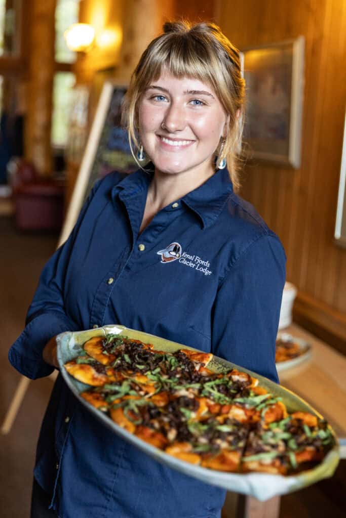 A staff member at Kenai Fjords Glacier Lodge serves a side dish during dinner service